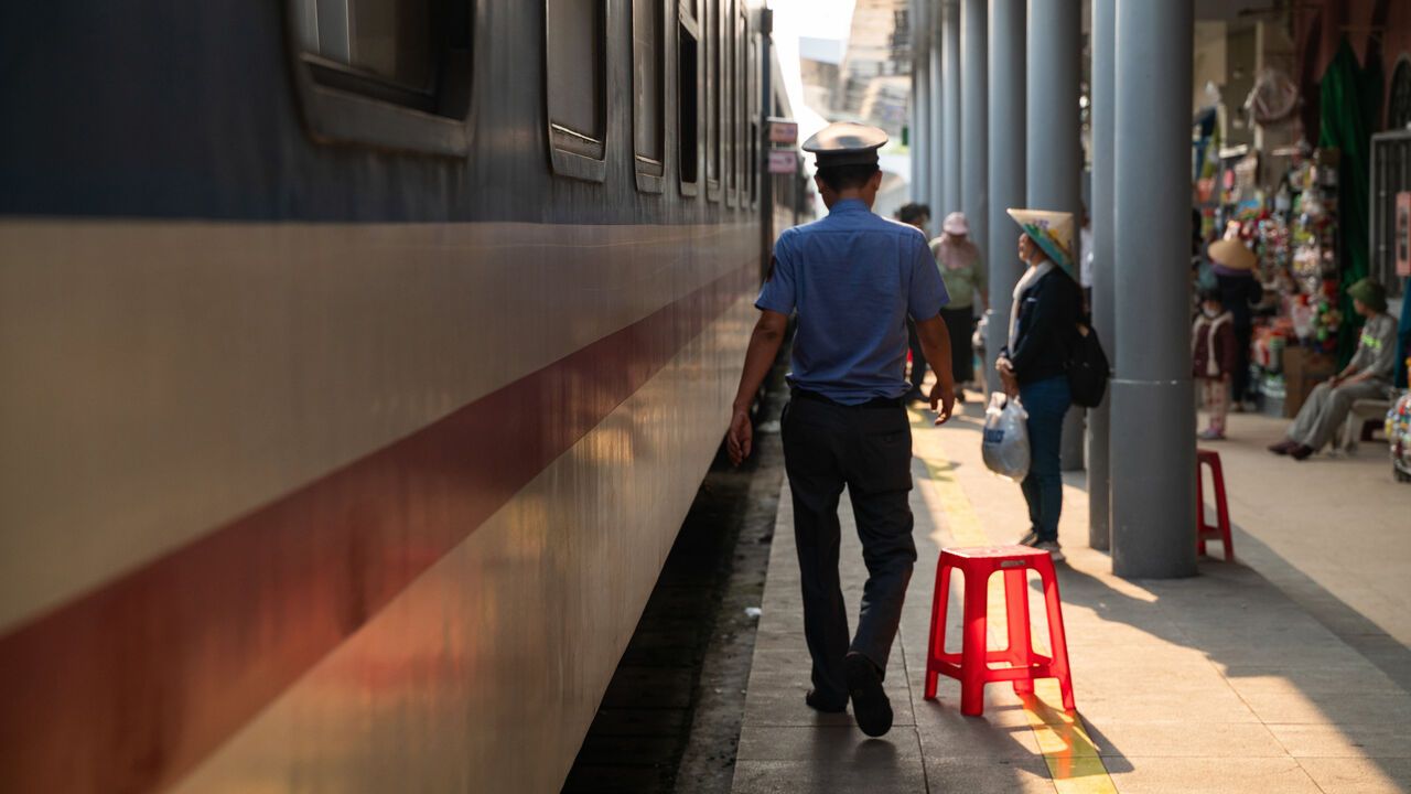 A view of a train station and passengers along the Ho Chi Minh City and Hanoi railway line in Vietnam.