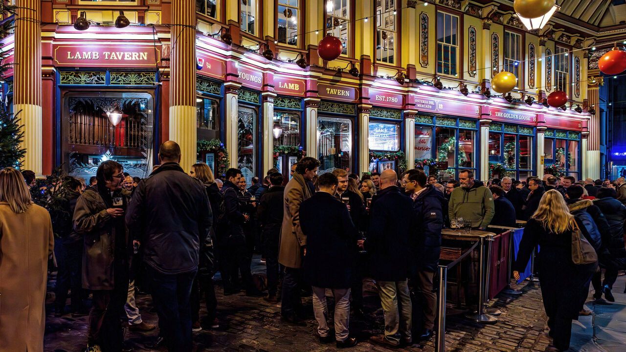A large group of people drinking outside a pub in Leadenhall Market