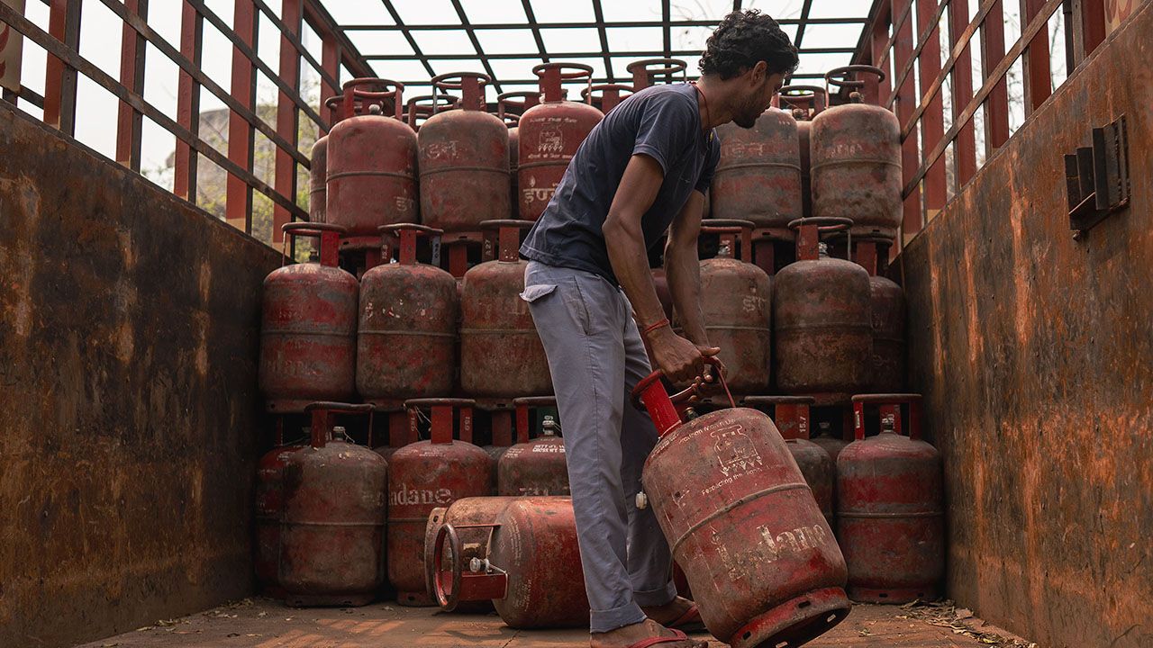 A worker loads LPG cylinders onto a truck in New Delhi, India.