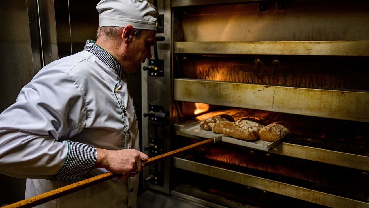 A baker puts bread into an oven in Germany.