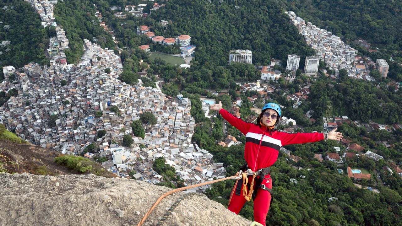 A tourist abseils at sunrise from Morro Dois Irmao, Rio de Janeiro .