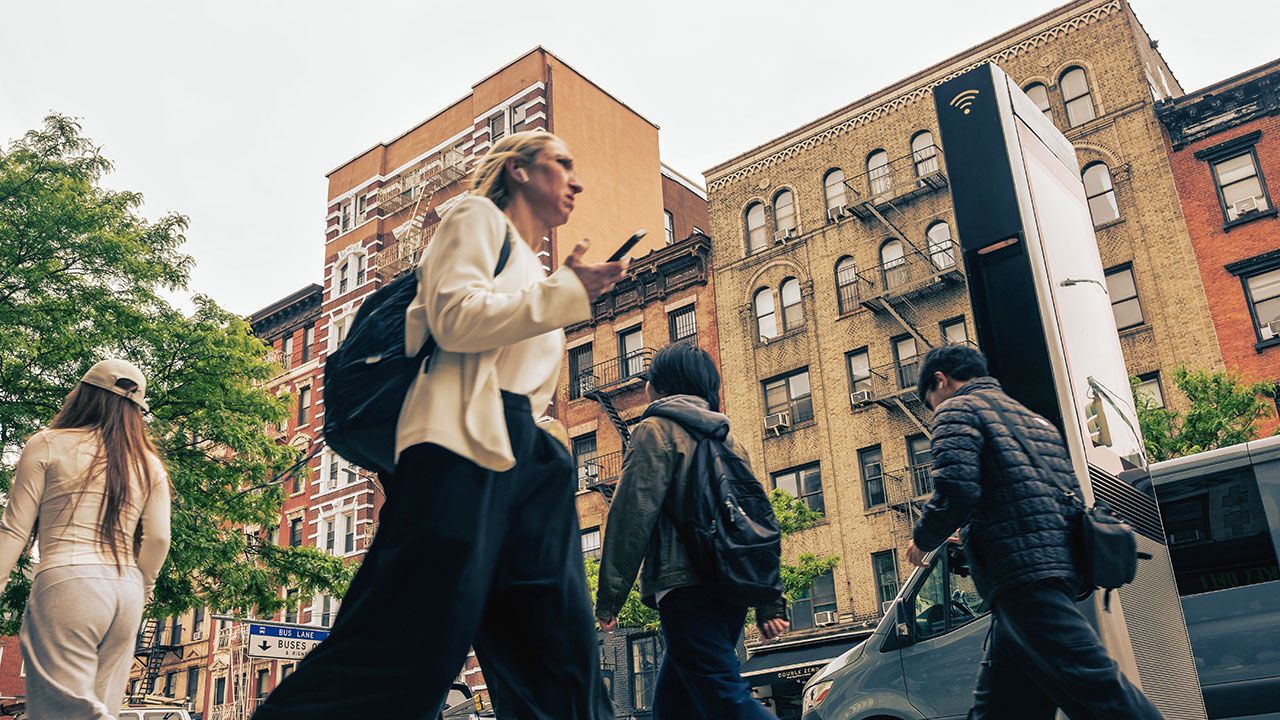 People walk past apartment buildings in NYC.