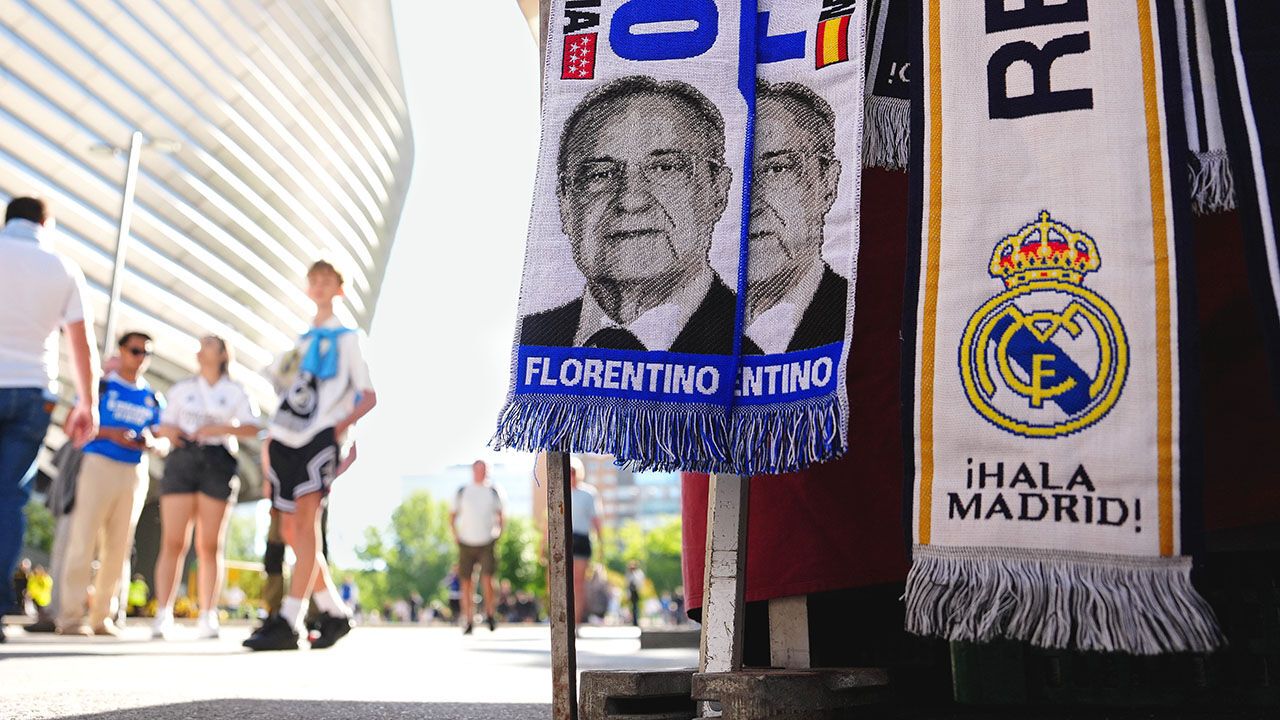 Real Madrid scarves depicting Real Madrid President Florentino Perez outside a stadium.