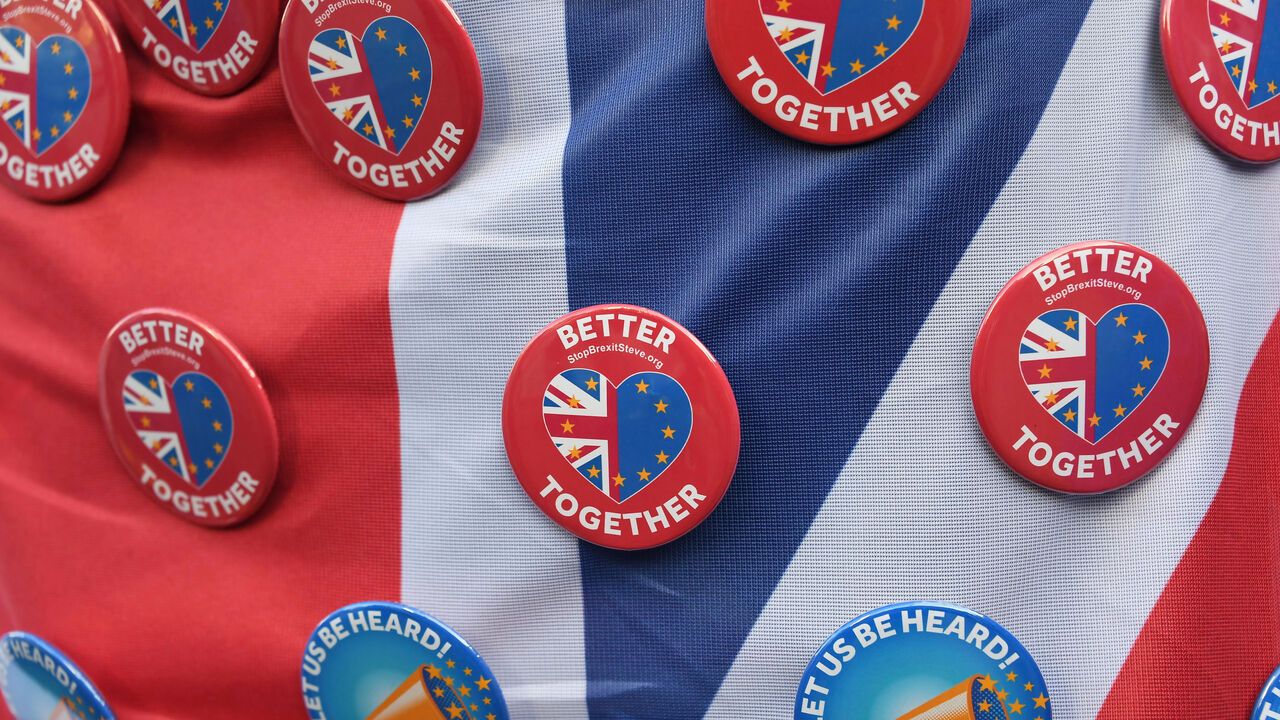 Anti-Brexit buttons sit on the Union Jack flag. Heart-shaped pin badges read 'better together' with half the heart a Union Jack, and the other half the EU flag.