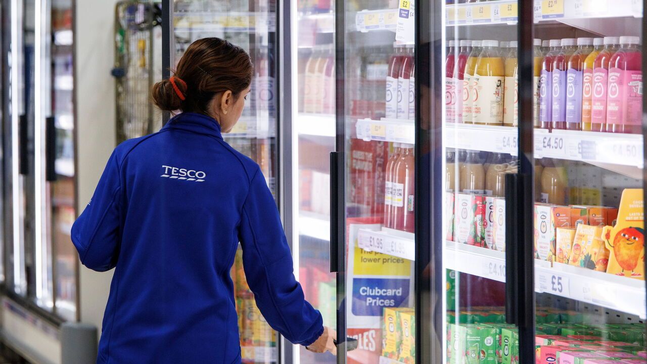A member of staff works at a Tesco Superstore in East London