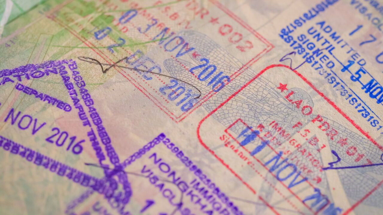 Passport Stamps are seen on the pages of an open passport.