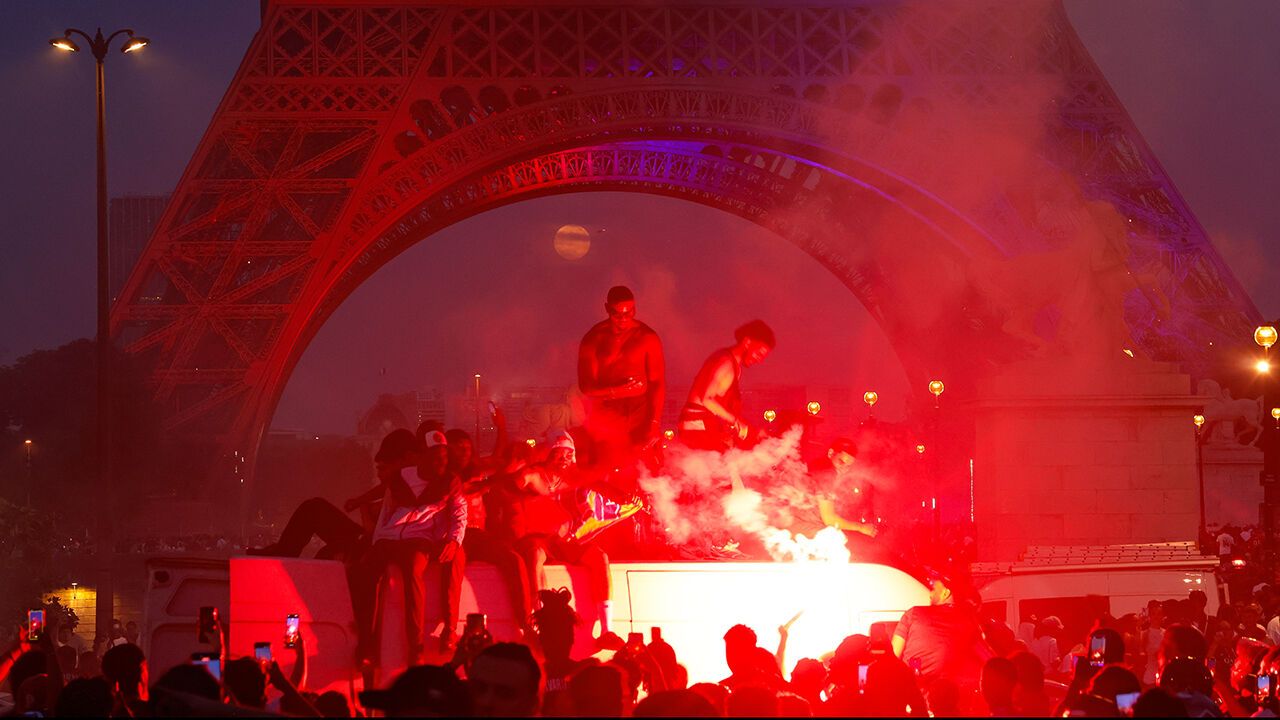 Football fans celebrate the victory of Paris Saint Germain over Arsenal in Paris
