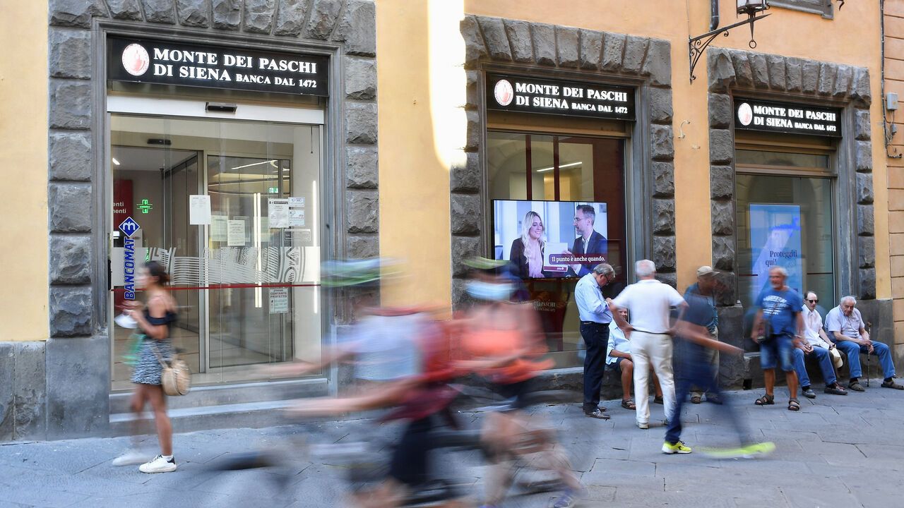 People pass in front of a branch of Monte dei Paschi di Siena (MPS), the oldest bank in the world, Siena, Italy.