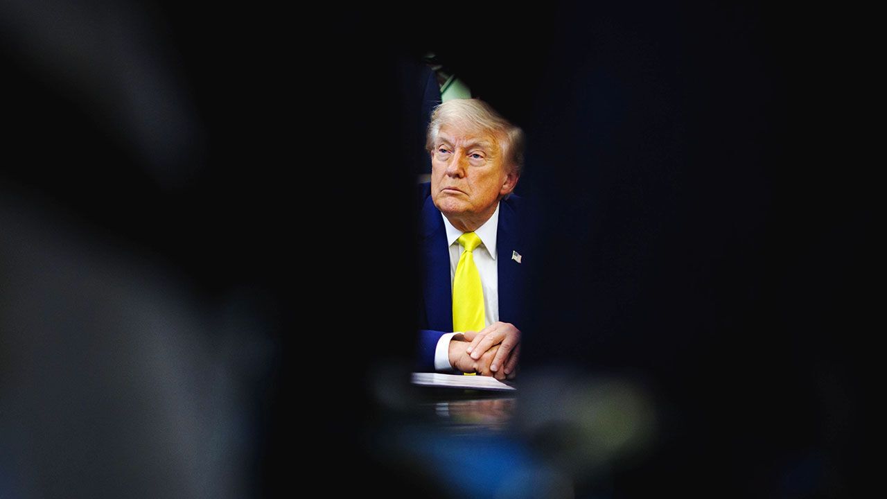 President Donald Trump looking isolated in shadows