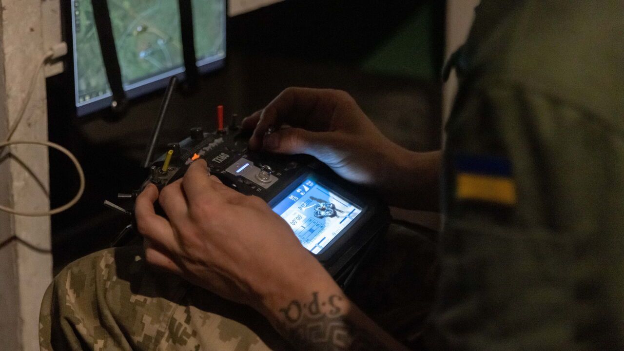 Servicemen of the 116th Mechanized Brigade prepare Ukrainian-made P1-Sun interceptor drones for use while sitting in a shelter.