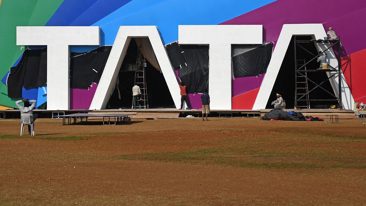 Workers are seen working near a Tata logo in Mumbai, India