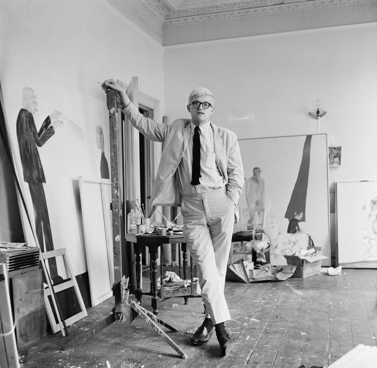 David Hockney in a studio with some of his work, circa 1967