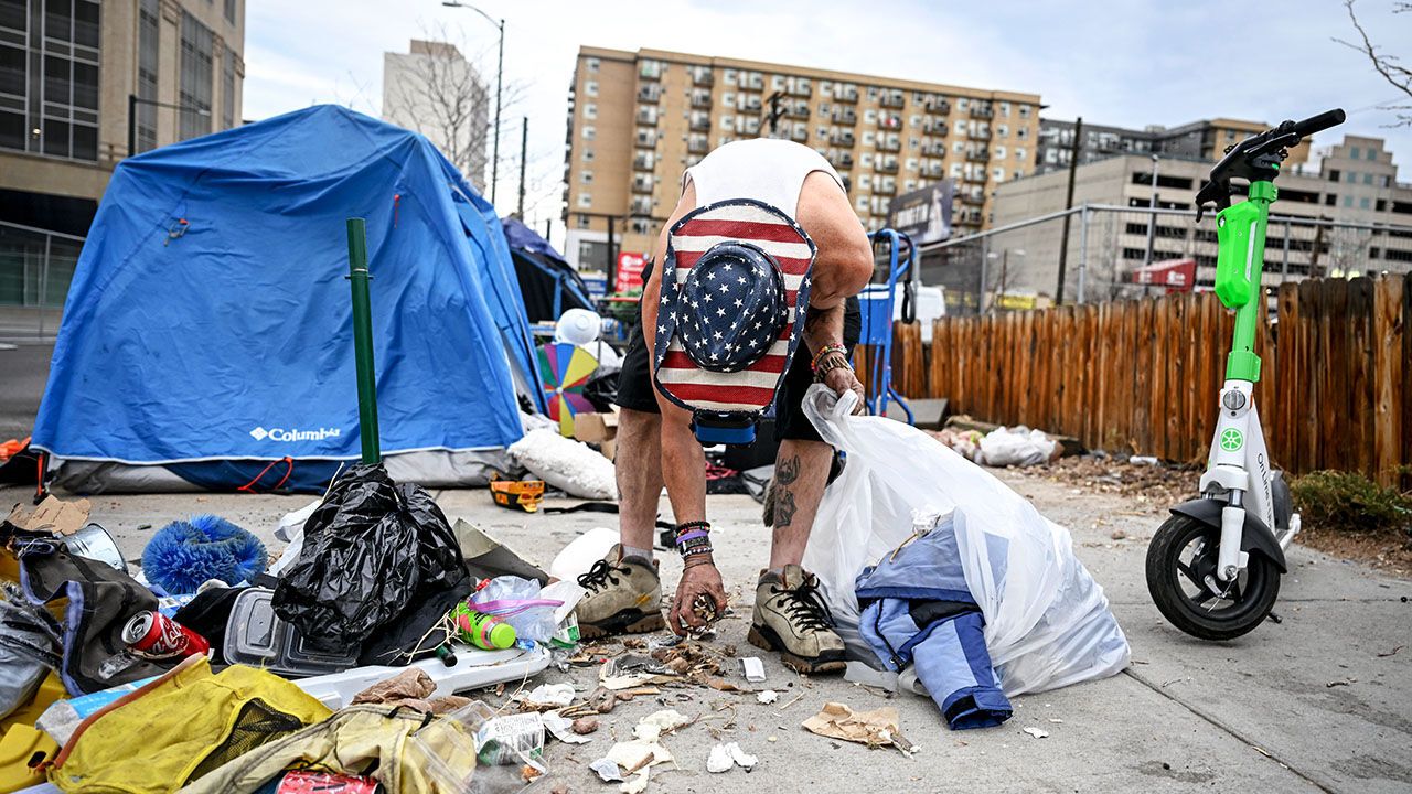 A homeless person clears away their tent in Denver, Colorado.
