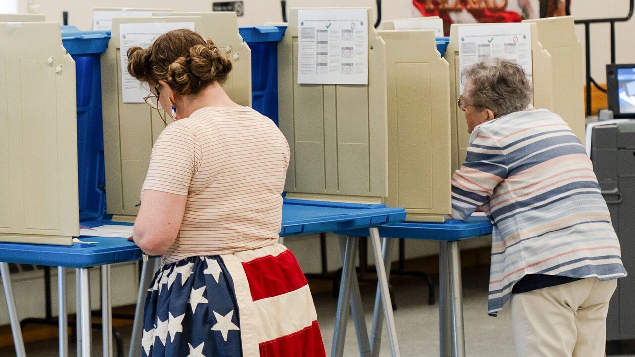 A woman wearing The Stars and Stripes skirt fills out her ballot at a polling place in Belfast, Maine, USA.