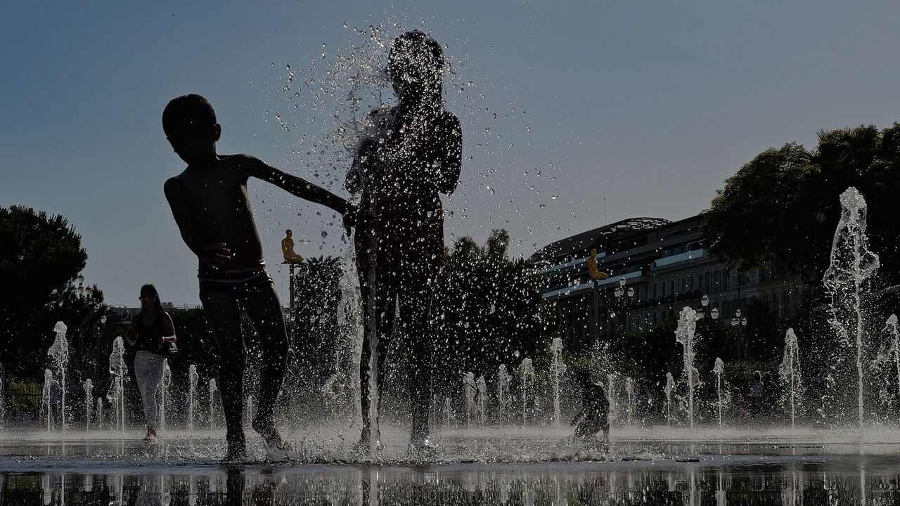 Children play in a water mirror fountain on the French riviera city of Nice.
