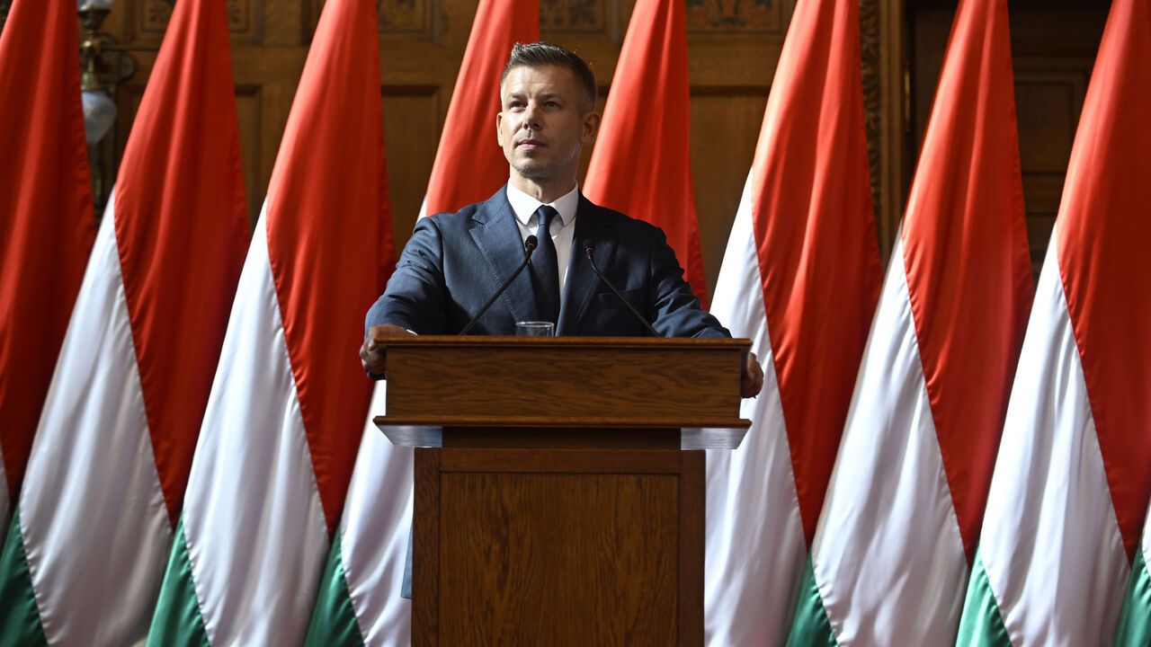 Peter Magyar, Prime Minister of Hungary, in front of a row of Hungarian flags.