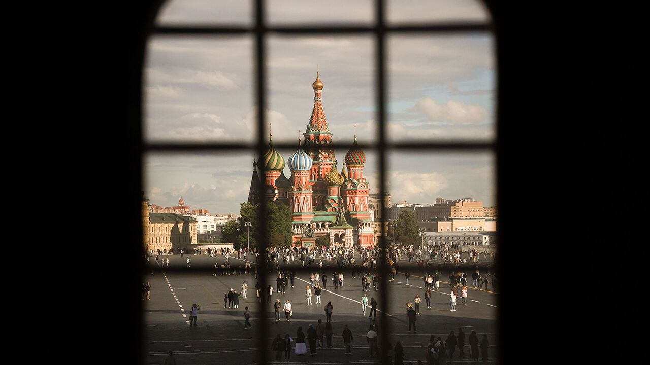 People enjoy the sun walking in Red Square near the Kremlin in Moscow, Russia