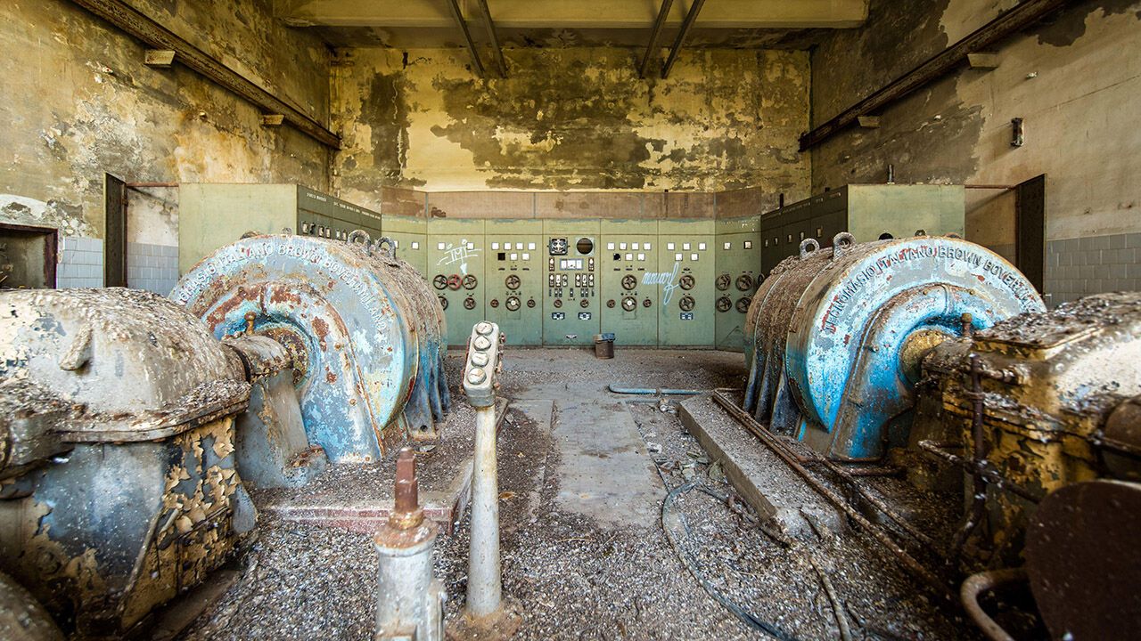 A derelict power station control room with rusty turbines, peeling paint and vintage industrial panels in Bern, Switzerland