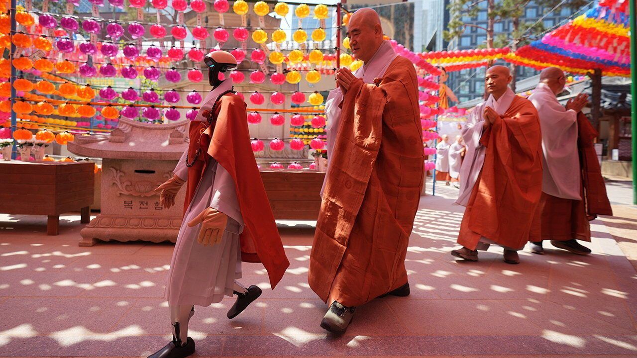 A humanoid robot, left, and Buddhist monks pass around a pagoda during an ordination ceremony ahead of upcoming Buddha's birthday on May 24 at Jogye temple in Seoul, South Korea, May 6, 2026.