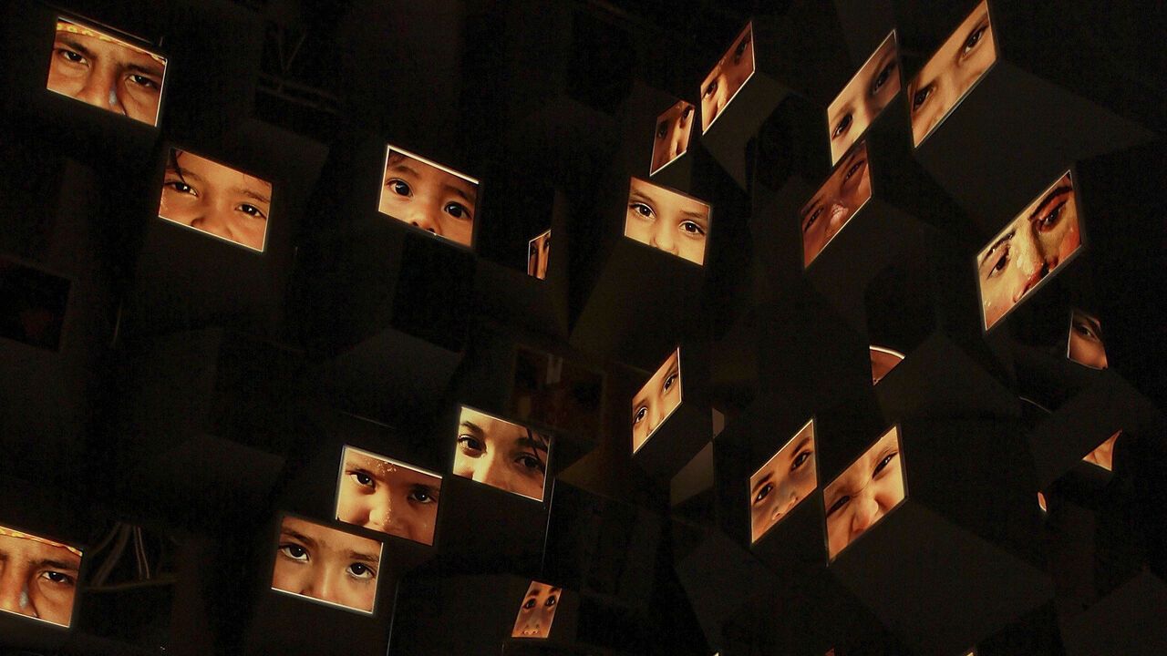 General view of 'En Tus Sentidos' by the artist artist Willy Sousa. lots of images of faces are shown.