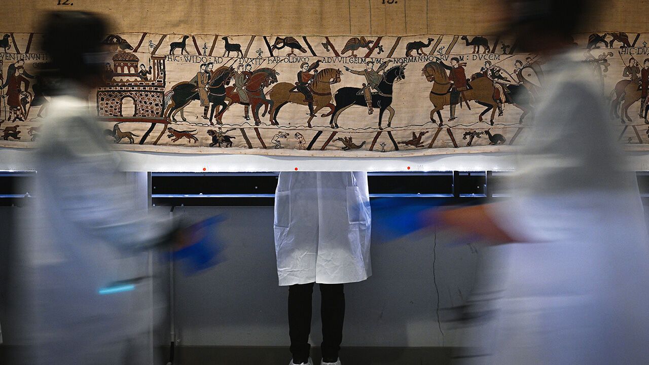 Workers and volunteers, rest before preparing to pack the Bayeux Tapestry in a crate for transfer to the British Museum.