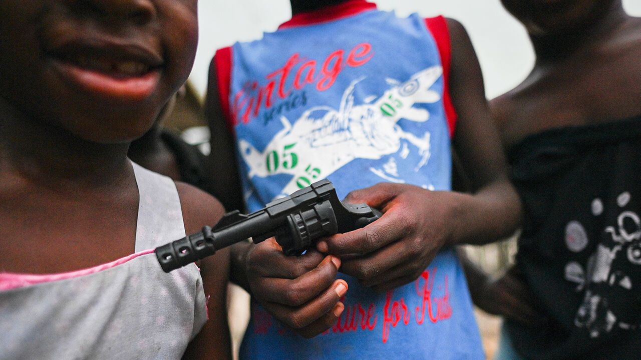 A boy holds a toy gun on a street of the Puente Nayero humanitarian area in Buenaventura, Valle del Cauca, Colombia