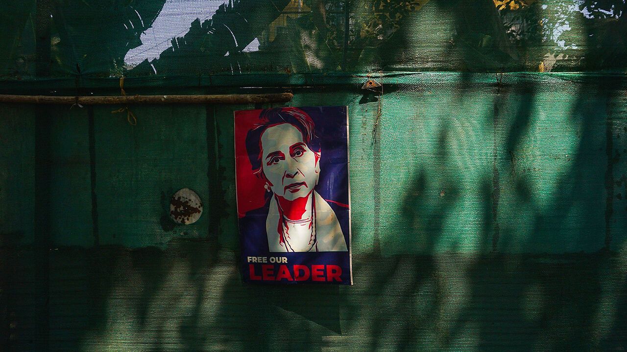 A poster of Aung San Suu Kyi is displayed on a wall as protesters take part in a demonstration against the military coup in front of the Indonesian embassy in Yangon on February 24, 2021.