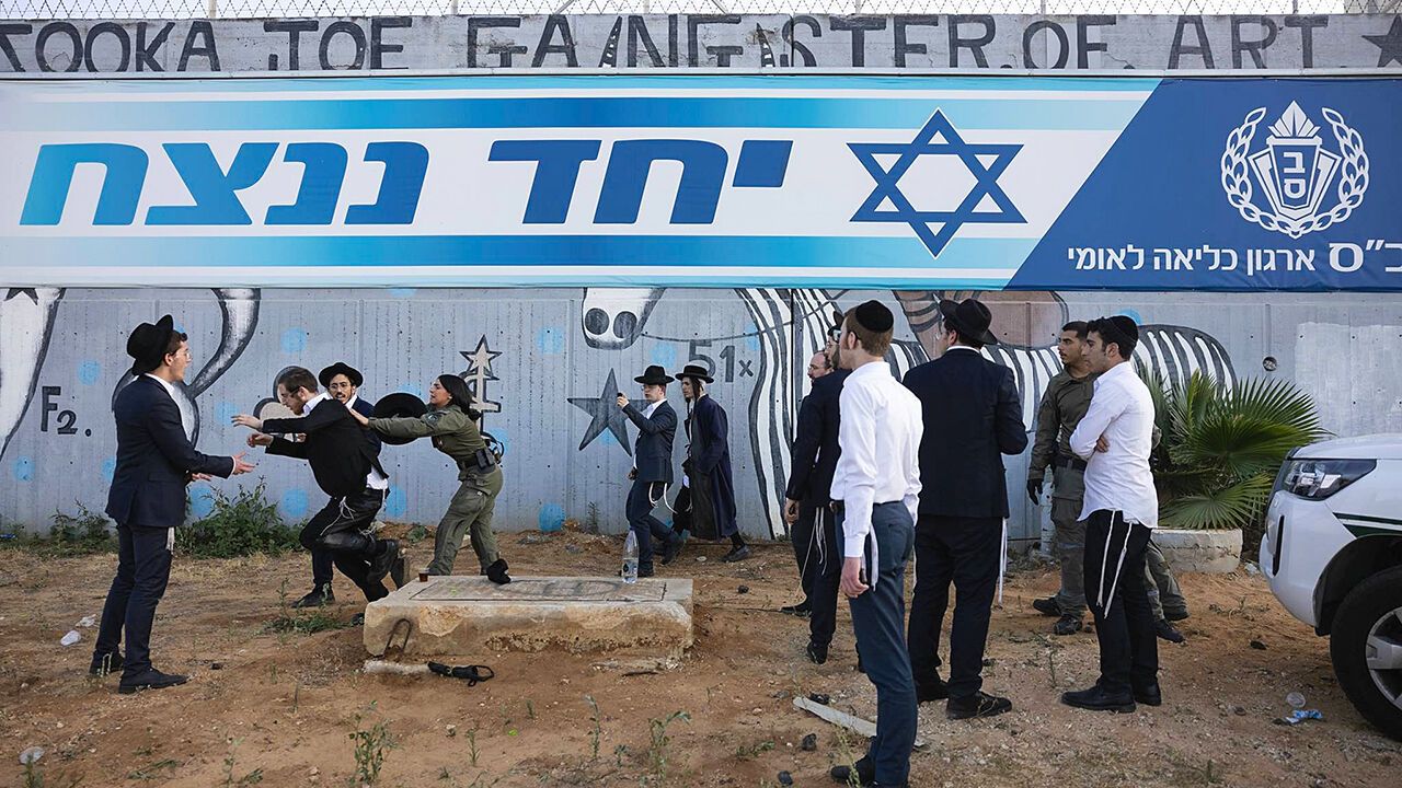 Israeli police forces attempt to disperse ultra-Orthodox Jews protesting against the recent arrests of draft dodgers