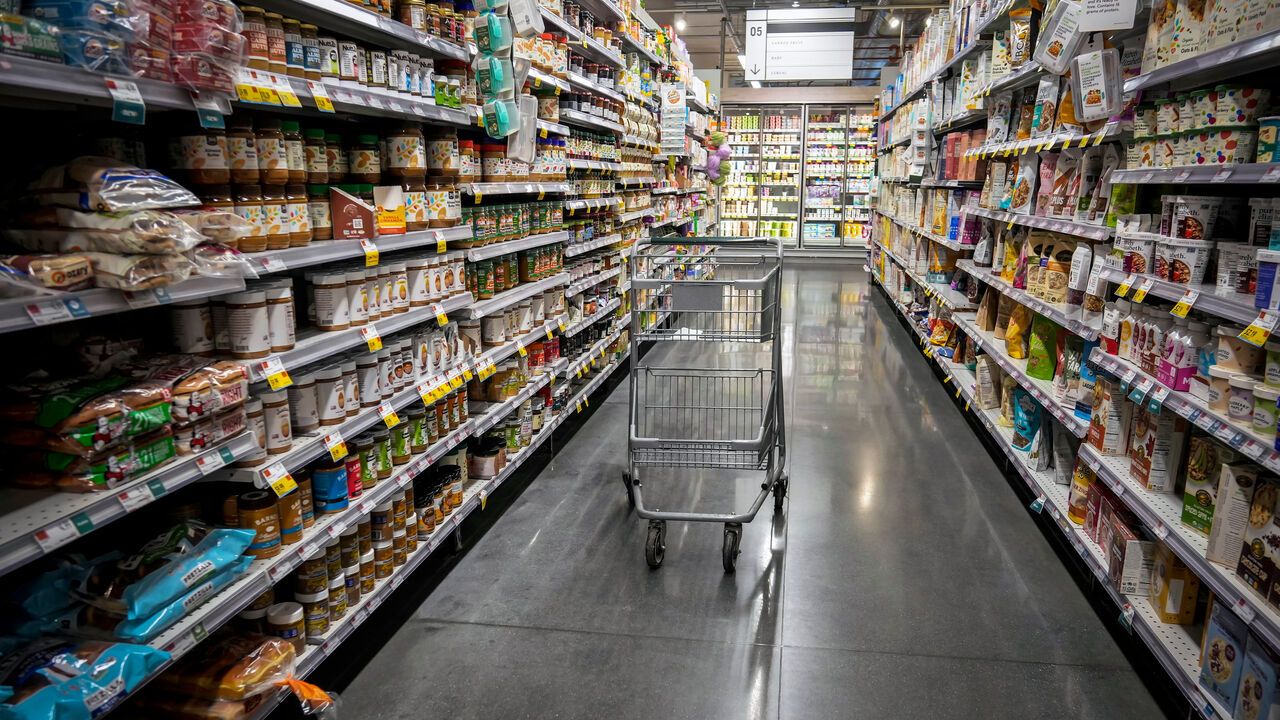 Empty shopping trolley in a supermarket aisle.