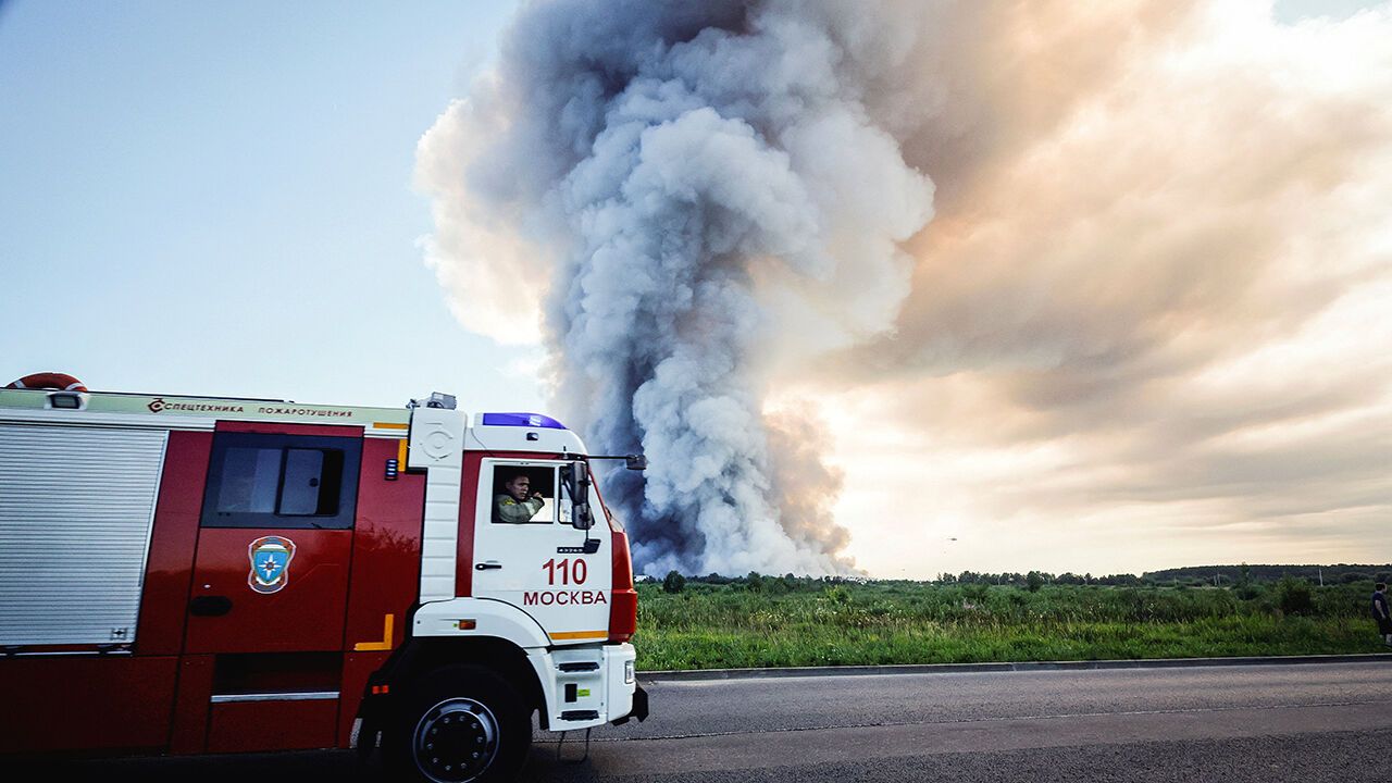 Firefighters drive past the smoke of a fire at the Russian e-commerce firm Wildberries' logistics complexes in the town of Elektrostal outside Moscow on July 18, 2026