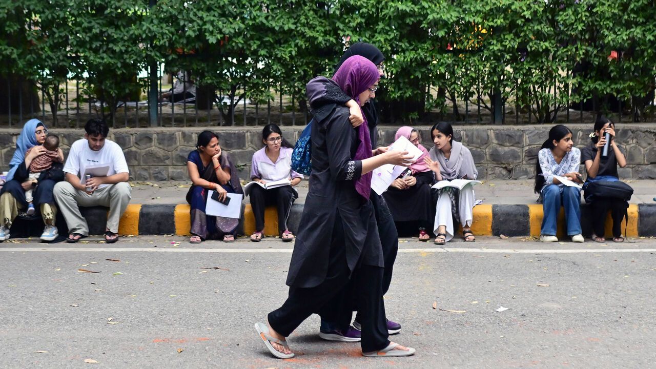 National Eligibility cum Entrance Test (NEET) candidates revise study material while waiting outside an examination centre.