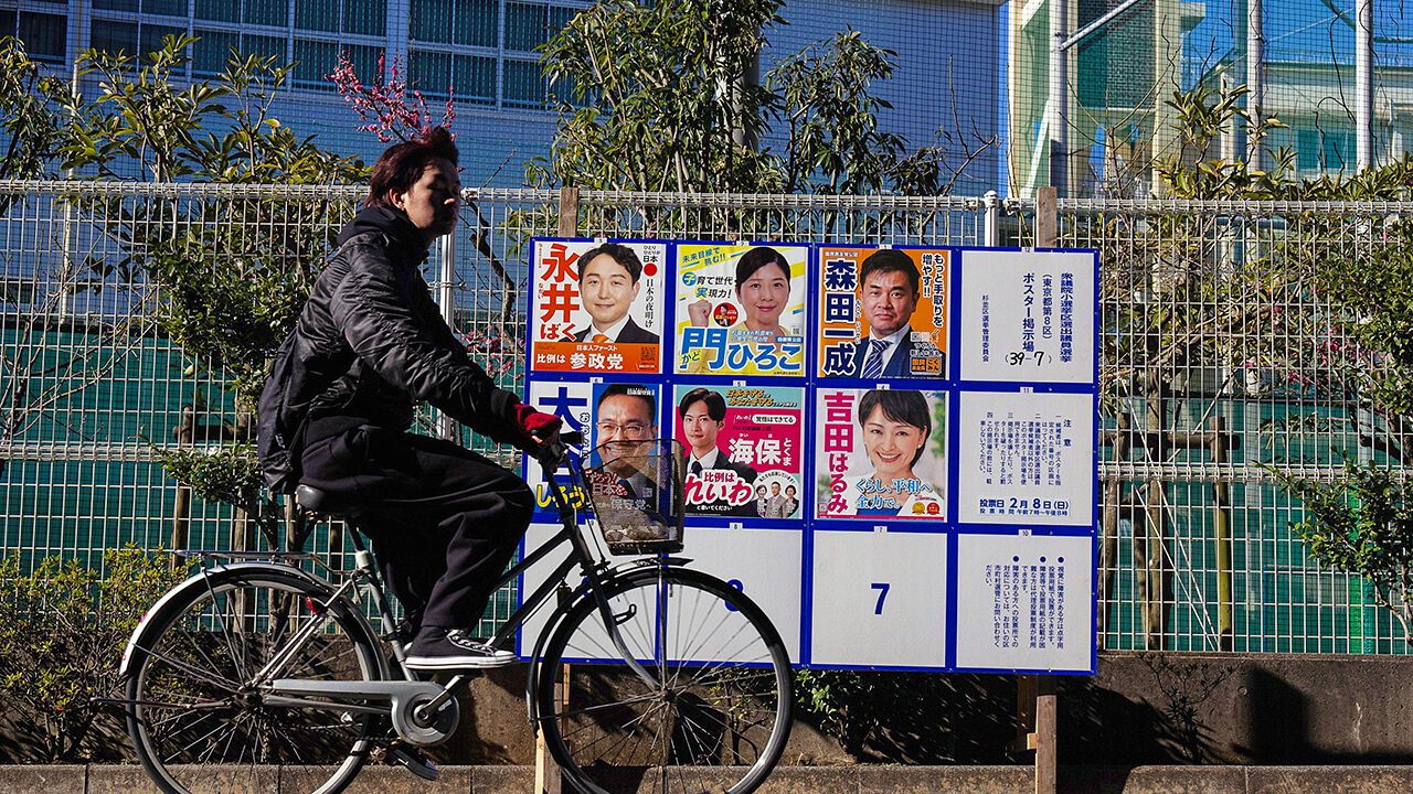 A cyclist passes an election campaign poster ahead of the lower house election in Tokyo, Feb. 3, 2026.