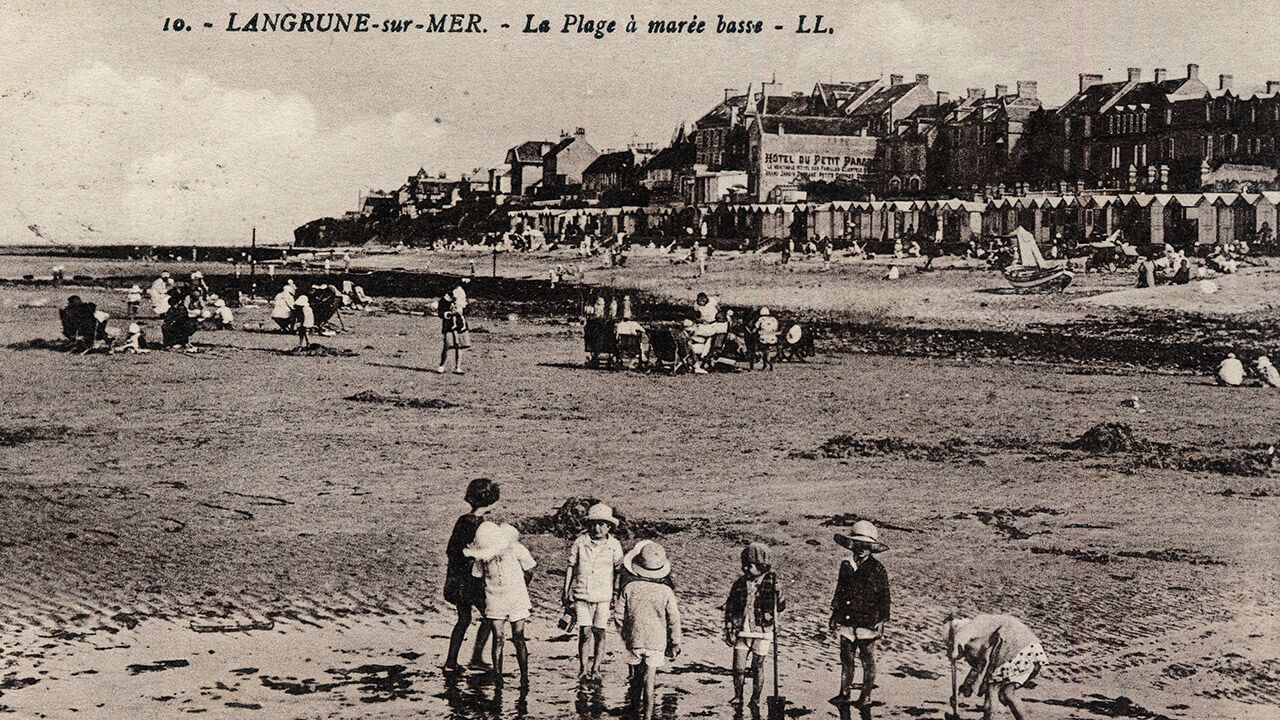 A group of children playing on the beach at Langrune-sur-Mer in Calvados, Normandy. Postcard late 19th-early 20th century