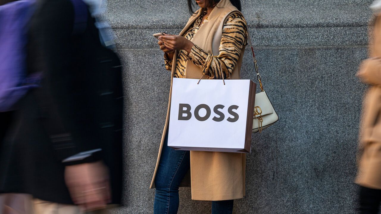 A shopper carries a Hugo Boss bag.