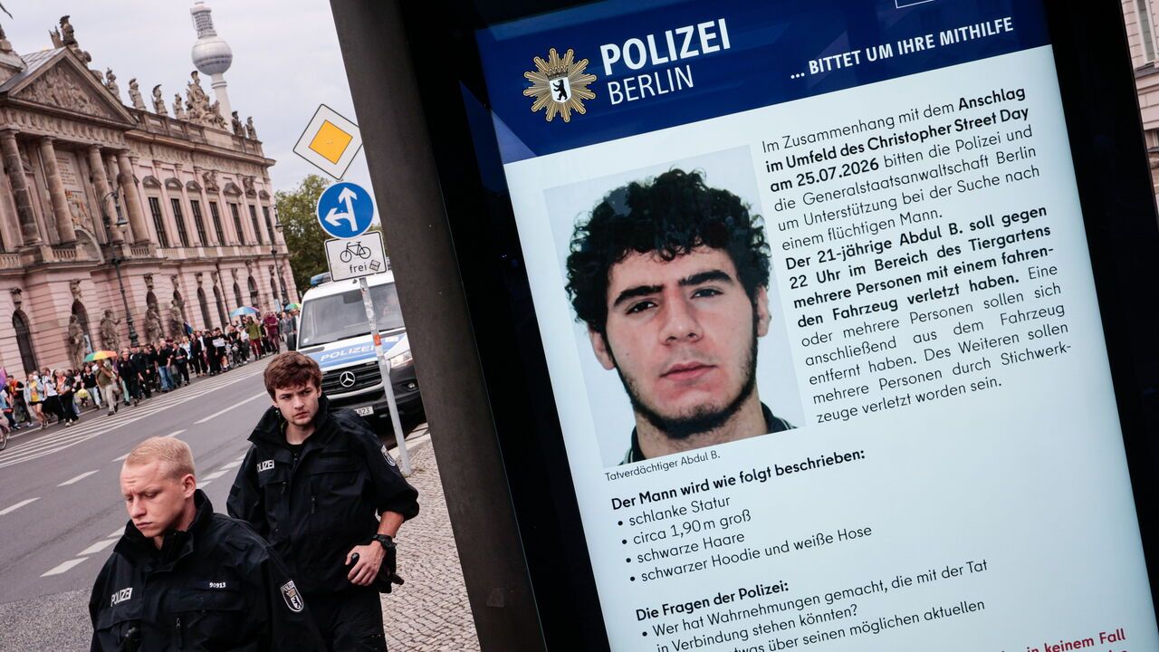 A public information screen displays a Berlin police appeal for information about Abdul Ballout, the suspected attacker in the car attack near the CSD Pride parade.