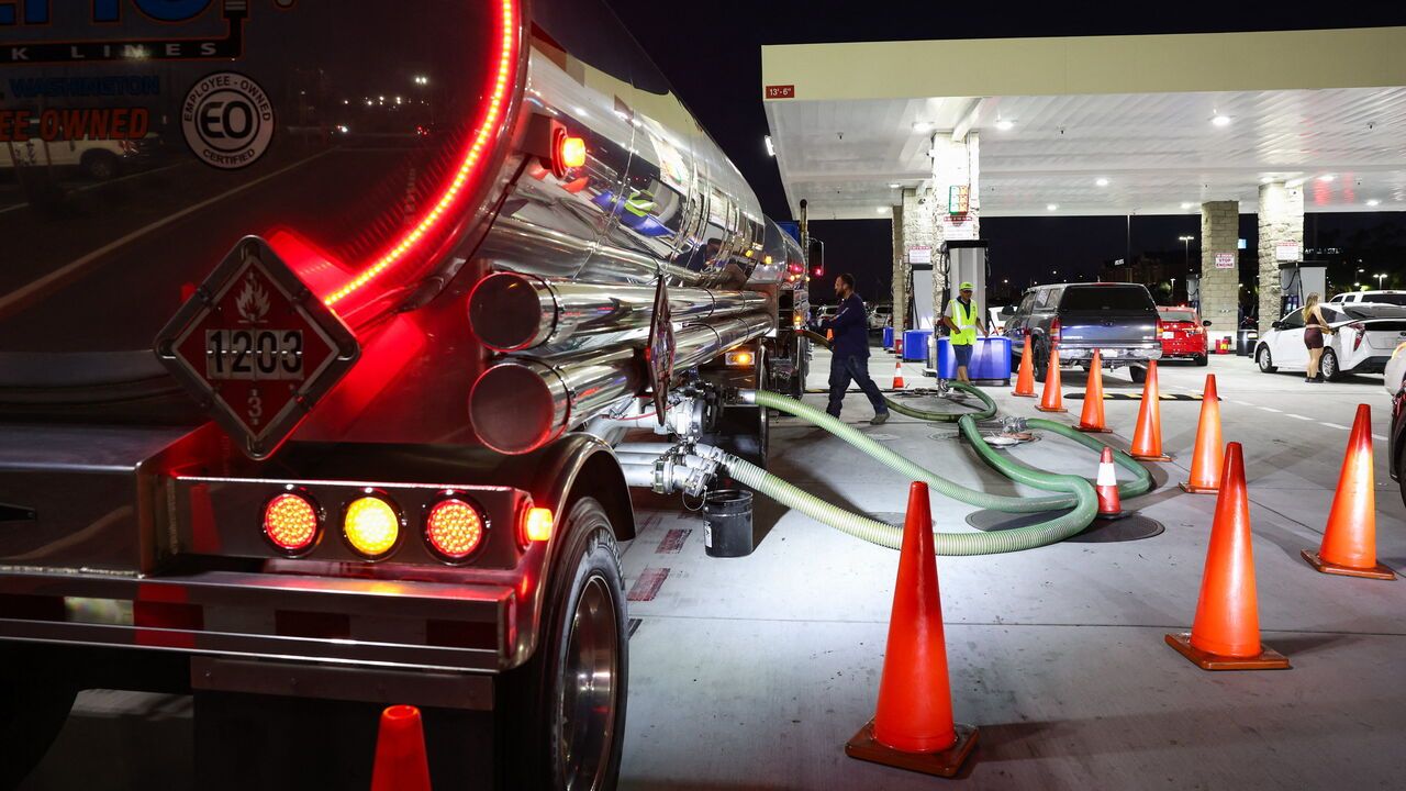 Workers prepare a tanker truck to unload a delivery of gasoline at a Costco gas station in Hawthorne, California,