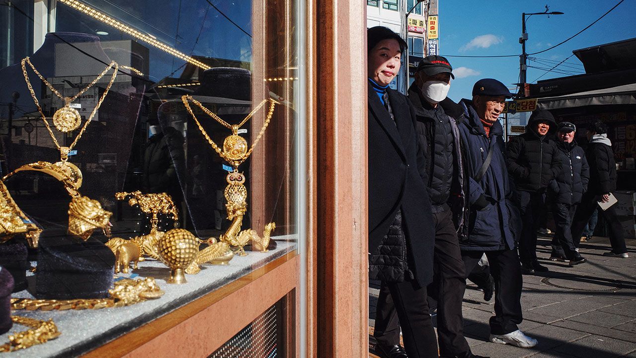 Pedestrians walk past a shop selling gold jewellery in Seoul on February 5, 2025.