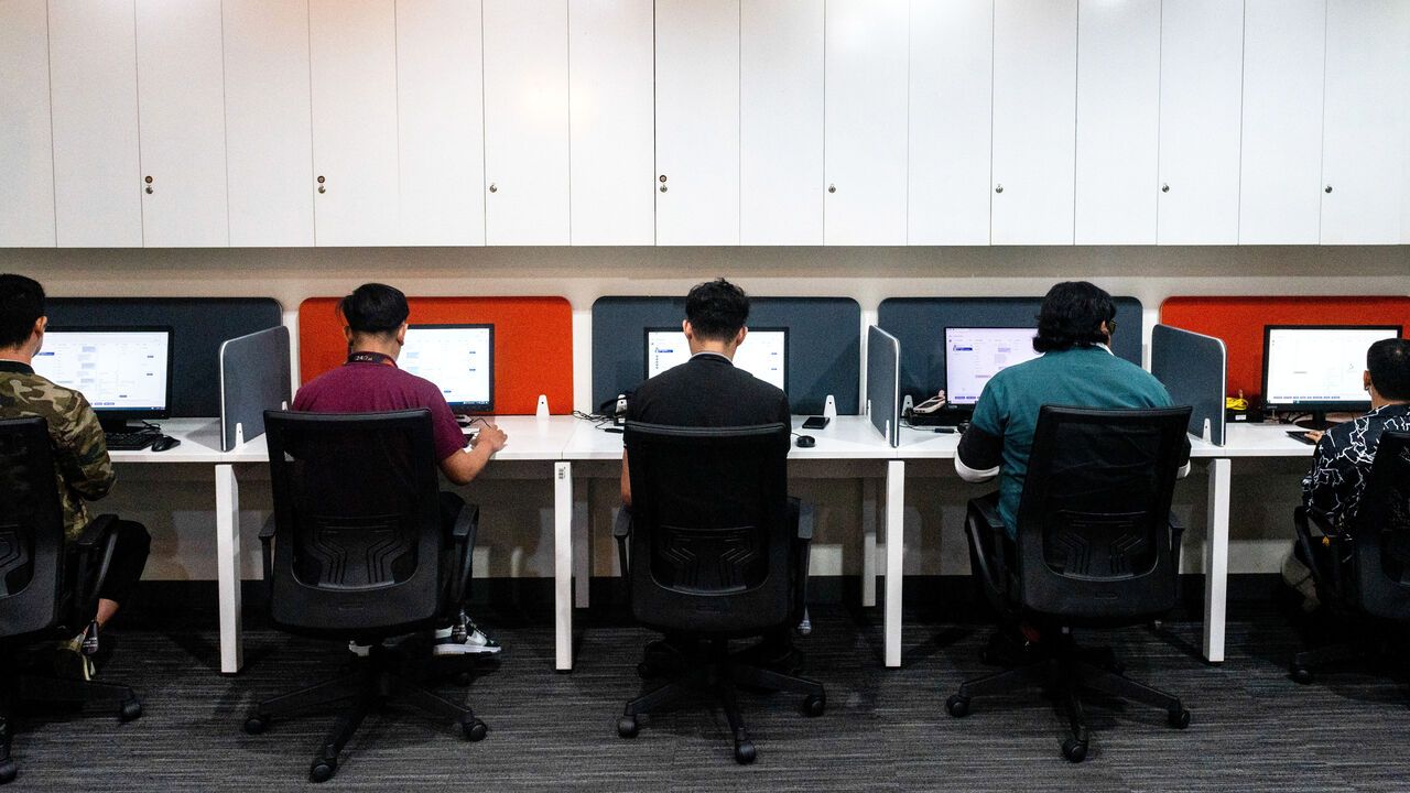 Customer agents sit behind computers on the AI training floor for a call centre in Manila, Philippines.
