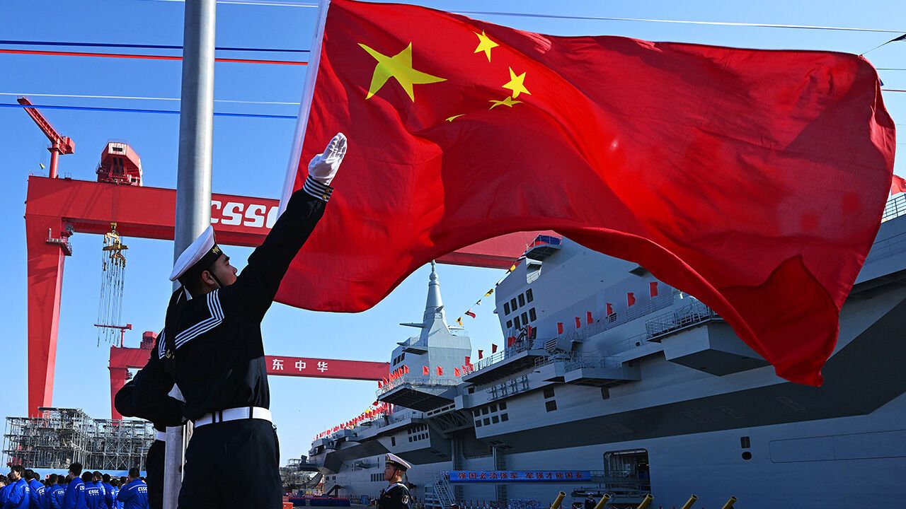 A flag-raising ceremony is held during the launching ceremony to unveil China's first Type 076 new-generation amphibious assault ship, the Sichuan, at Hudong-Zhonghua Shipbuilding