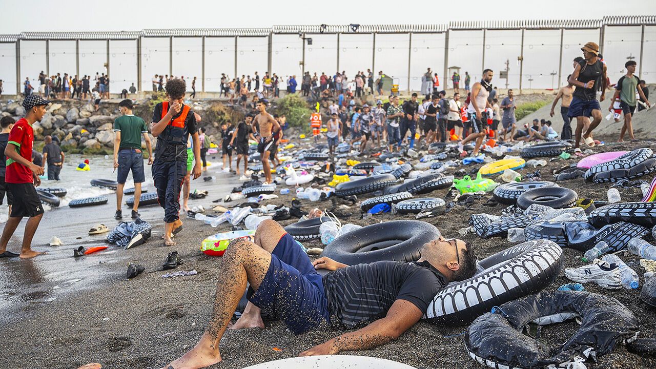 A man rests on the beach as hundreds of migrants attempted to swim from Morocco to the Spanish city of Ceuta.