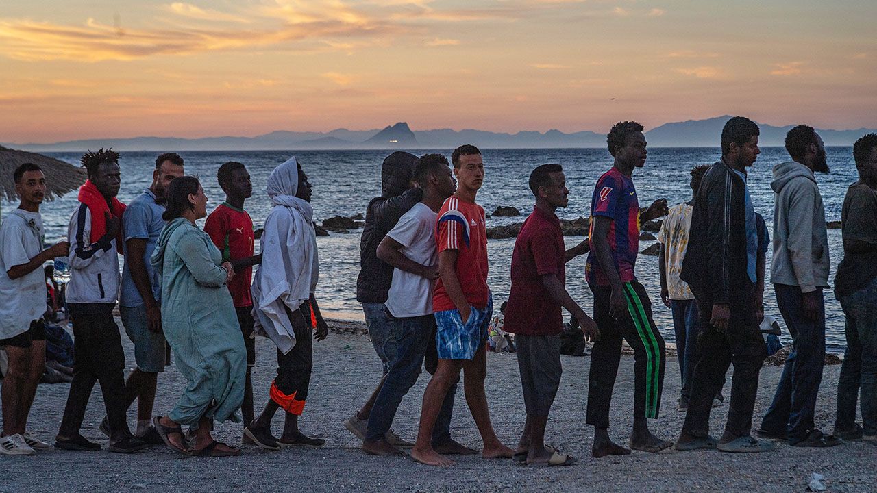 Migrants who crossed from Morocco into Spain line up