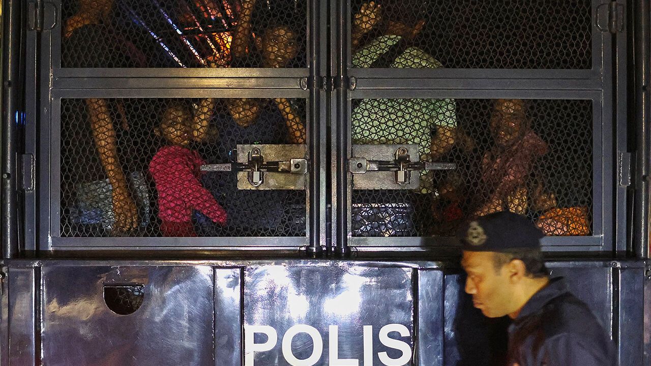 Rohingya refugees inside a truck as they are taken by police, in front of the office of the UN Refugee Agency, after being evicted from their homes, at Kuala Lumpur Malaysia.