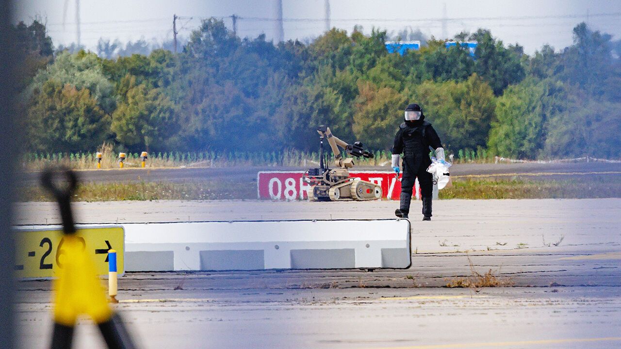 A policeman inspects a drone equipped with explosives discovered at Leipzig/Halle Airport