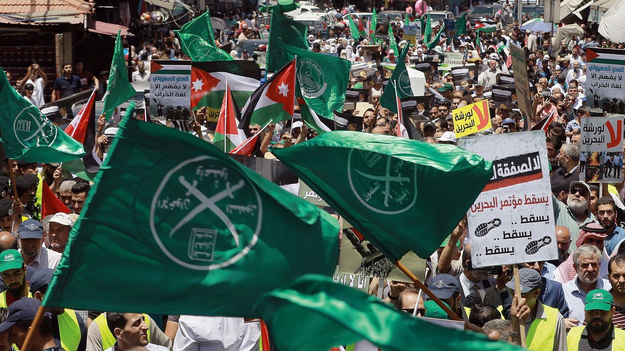 Flags of the Muslim Brotherhood are waved during a protest in Jordan.