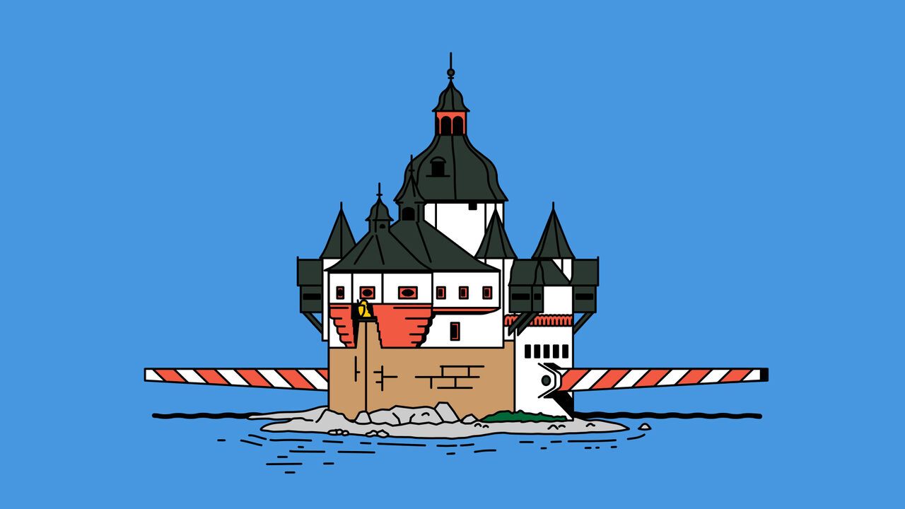 A turreted castle sitting on a tiny island with large toll barriers coming from out either side of the castle.