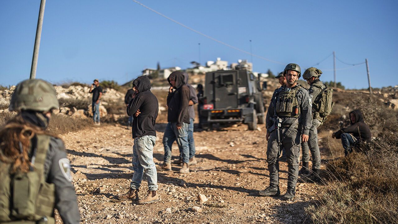 Settlers and IDF soldiers near the village of Qusra, West Bank