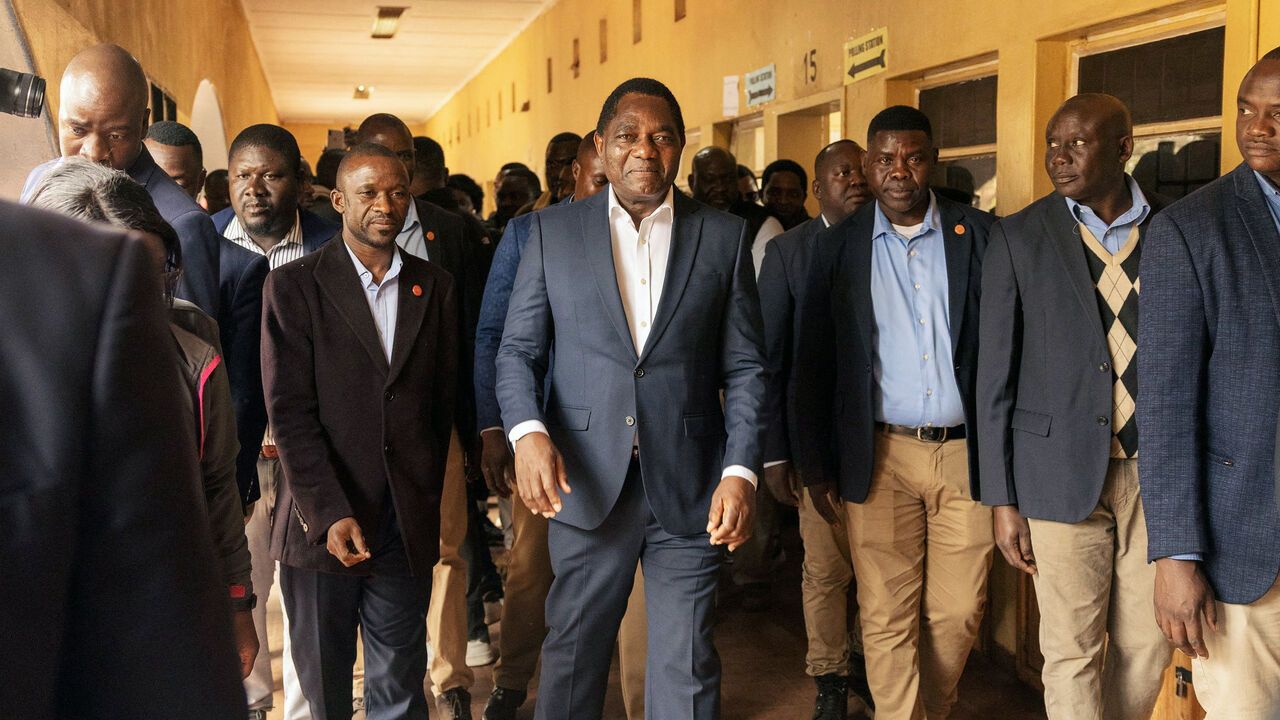 Zambian incumbent President and United Party for National Development (UPND) presidential candidate Hakainde Hichilema (C) leaves after casting his ballot