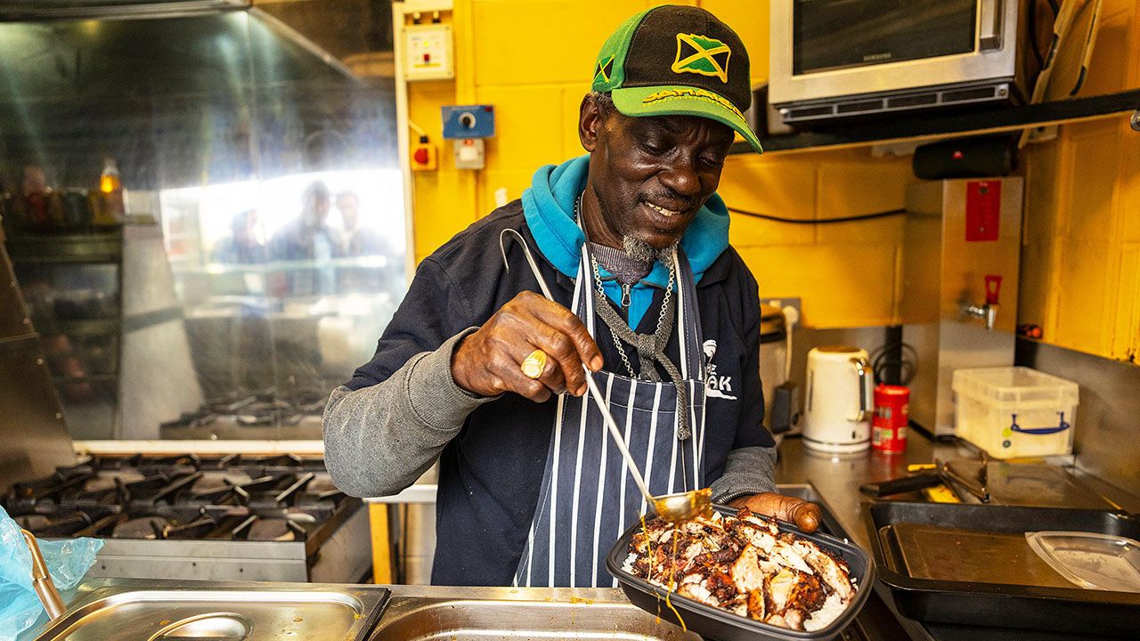Carlton Hunter cooks and serves customers at The Shak snack bar at Tooting and Mitcham Football Club