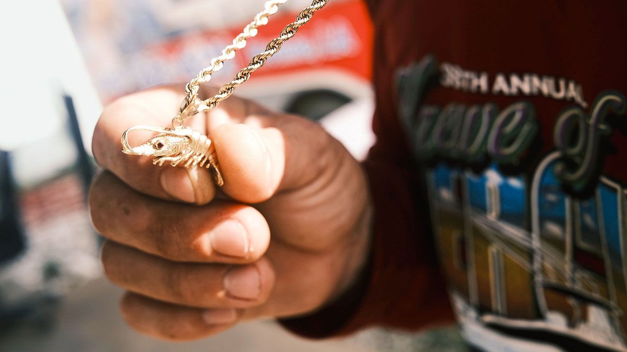 Shrimp fisherman holding necklace on the docks at Shrimp Kingdom, Terrebonne Parish, Louisiana.