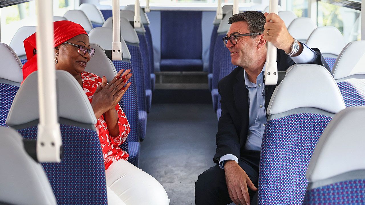 Britain's Prime Minister Andy Burnham speaks with Bemi Orojuogun during a bus ride.